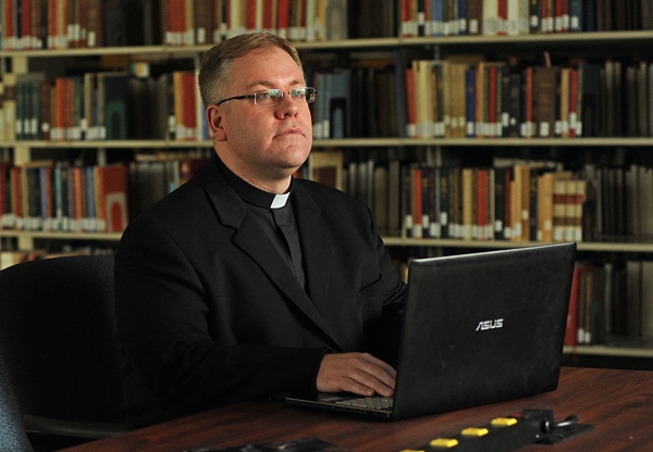 Deacon Martin Gallagher studies in the Christ the King Library as he prepares for his ordination at St. Joseph Cathedral on June 3. (Dan Cappellazzo/Staff Photographer)